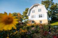 The Münter House in Murnau, a villa painted light blue, light yellow and white in the middle of a flowering summer garden.